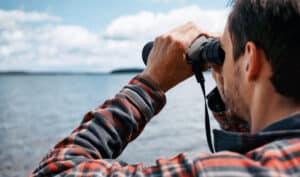 man-looking-through-binolculars