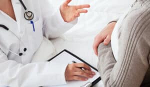 overhead-shot-of-doctor-reviewing-paperwork-with-patient VTE risk assessment information for healthcare professionals